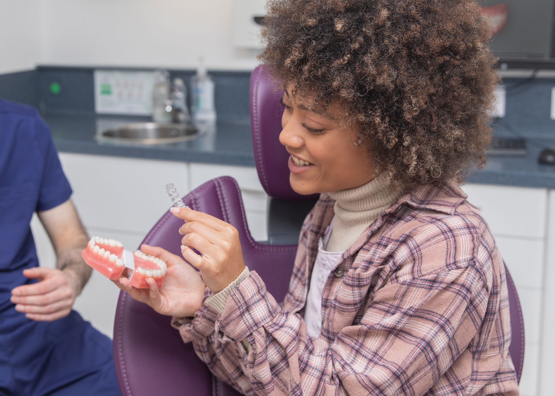 Woman fitting Invisalign clear aligner